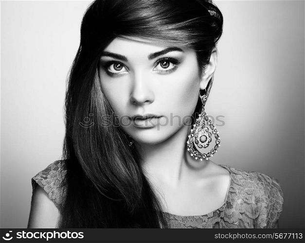 Portrait of beautiful young woman with earring. Jewelry and accessories. Perfect makeup. Fashion photo. Black and white