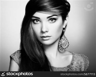 Portrait of beautiful young woman with earring. Jewelry and accessories. Perfect makeup. Fashion photo. Black and white