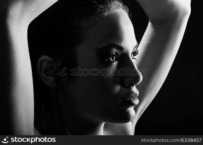 Portrait of beautiful young woman with green eyes on black background