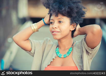 Portrait of beautiful young woman with hands in hair