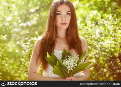 Portrait of beautiful young woman with lily of the valley. Portrait of beautiful young woman with lily of the valley. Girl on nature. Spring flowers. Fashion beauty