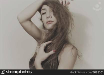 portrait of beautiful young woman with long curly hair on white background