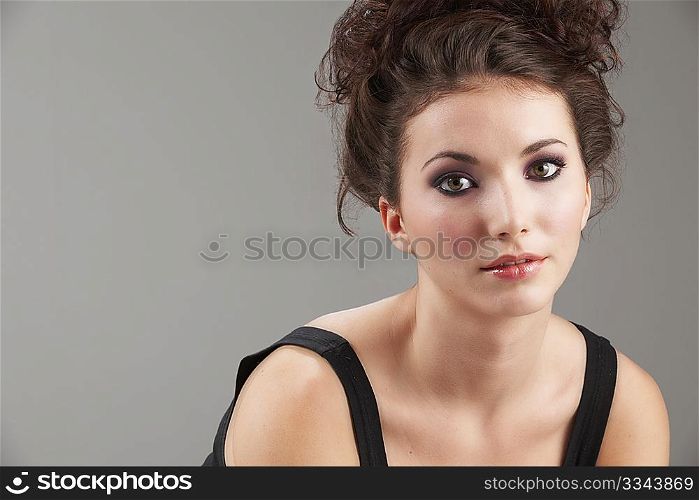 Portrait of beautiful young woman with make-up on grey background
