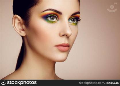 Portrait of beautiful young woman with rainbow make-up. Girl summer. Long eyelashes, vivid colorful eyeshadows. Multicolored