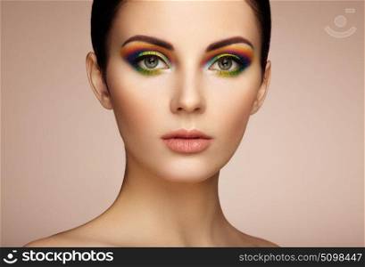 Portrait of beautiful young woman with rainbow make-up. Girl summer. Long eyelashes, vivid colorful eyeshadows. Multicolored
