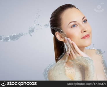 Portrait of beautiful young woman with water splashes