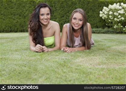 Portrait of beautiful young women with long hair lying in park