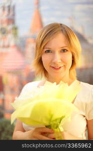 portrait of beauty blond girl with flowers bouquet, looking at camera and smiling