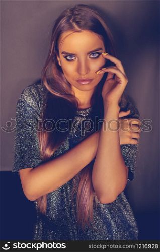 Portrait of Beauty fashion model posing in front of the wall looking at the camera beautiful young woman girl with long hair