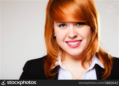Portrait of beauty redhair smiling business woman or student girl. Studio shot on gray background