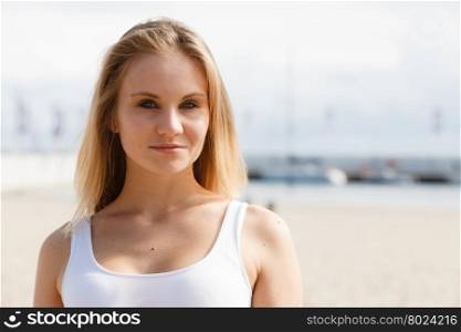 Portrait of beauty woman on marina. Gorgeous lovely blondie girl portrait. Attractive happy cute girl in white t-shirt on marina place.