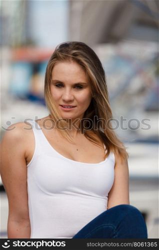 Portrait of beauty woman on marina. Gorgeous lovely blondie girl portrait. Attractive happy cute girl in white t-shirt on marina place.