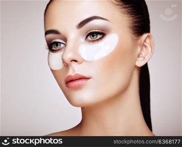 Portrait of Beauty Woman with Eye Patches. Woman Beauty Face with Mask under Eyes. Beautiful Female with natural Makeup and White Cosmetics Collagen Patches on Fresh Facial Skin