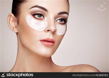 Portrait of Beauty Woman with Eye Patches. Woman Beauty Face with Mask under Eyes. Beautiful Female with natural Makeup and White Cosmetics Collagen Patches on Fresh Facial Skin
