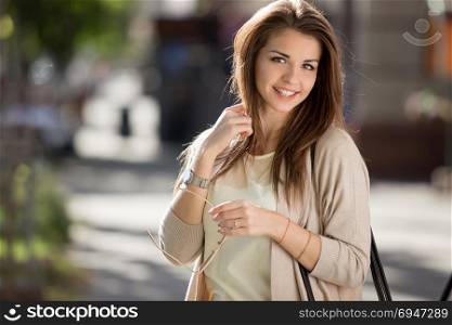 Portrait of beauty woman with perfect smile walking on the street and looking at camera. Portrait of beauty woman with perfect smile walking on the street and looking at camera.