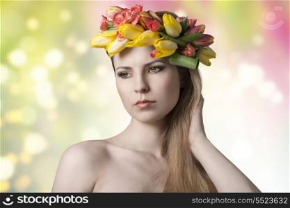 portrait of beauty young woman with long blonde hair, fresh sking, floral garland on her head and colorful make-up. Naked shoulders and romantic eyes
