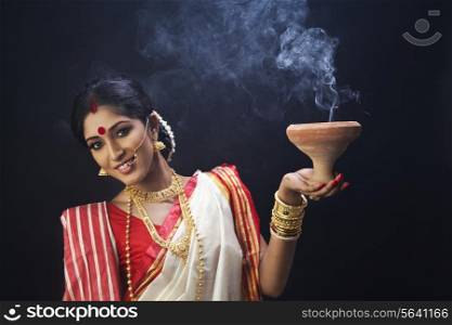 Portrait of Bengali woman holding a dhunuchi