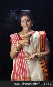 Portrait of Bengali woman holding a dhunuchi