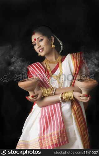 Portrait of Bengali woman holding dhunuchis
