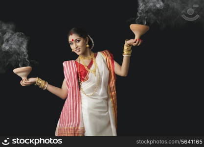 Portrait of Bengali woman holding dhunuchis