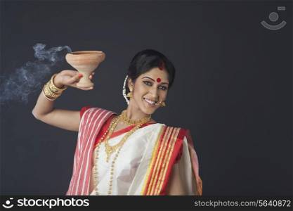 Portrait of Bengali woman with dhunuchi