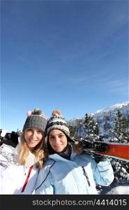 portrait of best friends at ski resort against deep blue sky background