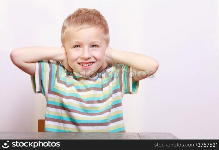 Portrait of blond boy child kid covering ears