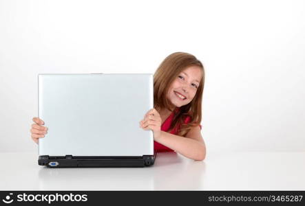 Portrait of blond little girl behind laptop computer