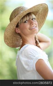 Portrait of blond woman outdoors wearing straw hat