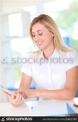 Portrait of blond woman using electronic tablet