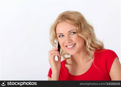 Portrait of blond woman with red shirt using mobile phone