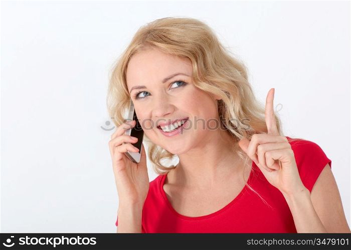 Portrait of blond woman with red shirt using mobile phone
