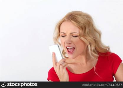 Portrait of blond woman with red shirt yelling on the phone