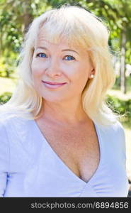 Portrait of blond woman with sapphirine eyes in blue