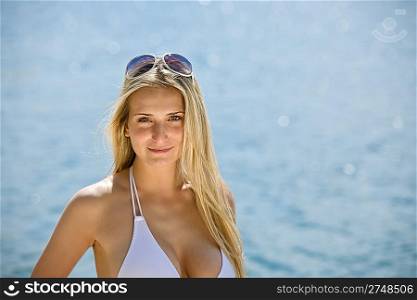 Portrait of blond woman with sunglasses at sea