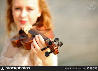 Portrait of blonde girl music lover on beach with a violin. Love of music concept.