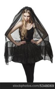 portrait of blonde girl with Halloween costume, funeral style and creative make-up wearing long dark veil and bizarre skirt