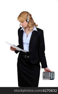 portrait of blonde in suit with headset holding notepad and calculator
