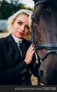 Portrait of blonde woman with horse, horseback riding. Brown stallion, leisure with animal, equestrian sport. Blonde woman with horse, horseback riding