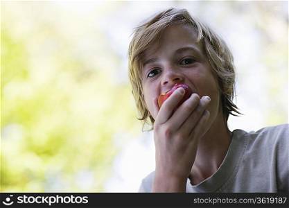 Portrait of boy (10-12) eating apple