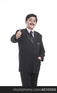 Portrait of boy dressed as businessman giving thumbs up