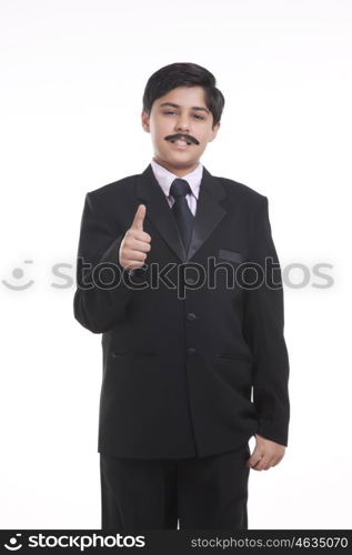 Portrait of boy dressed as businessman giving thumbs up