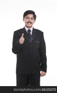 Portrait of boy dressed as businessman giving thumbs up