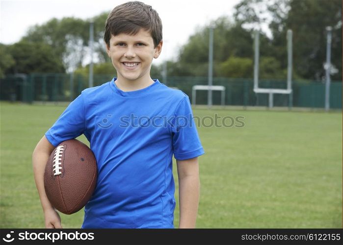 Portrait Of Boy Holding Ball On School Football Pitch