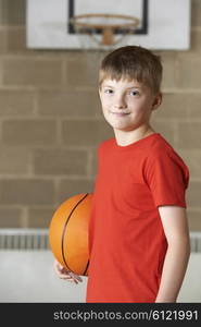 Portrait Of Boy Holding Basketball In School Gym