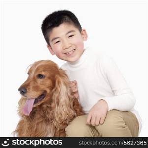 Portrait of Boy sitting next to his dog, studio shot