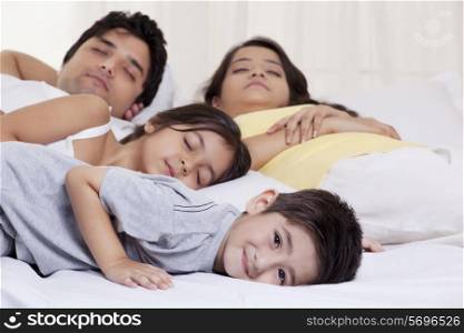 Portrait of boy smiling while his family sleeping in the background