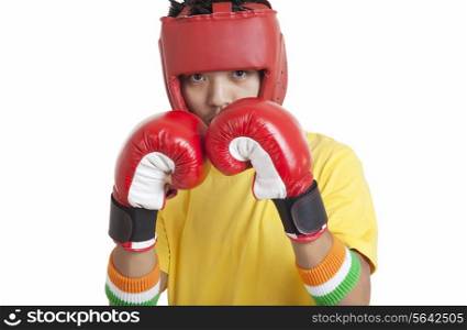 Portrait of boy wearing boxing gloves and head protector over white background