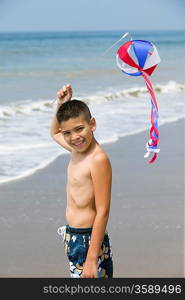 Portrait of boy with kite on beach