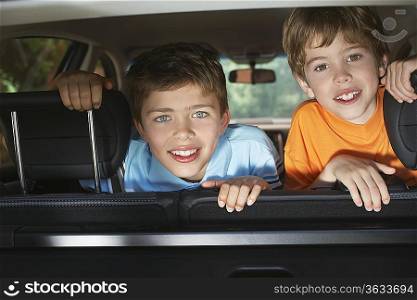Portrait of boys (6-11) in car interior, smiling